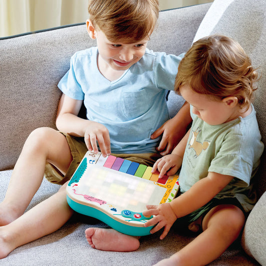 Toddler and big brother playing with the Dynamic Pixel Piano by Hape.