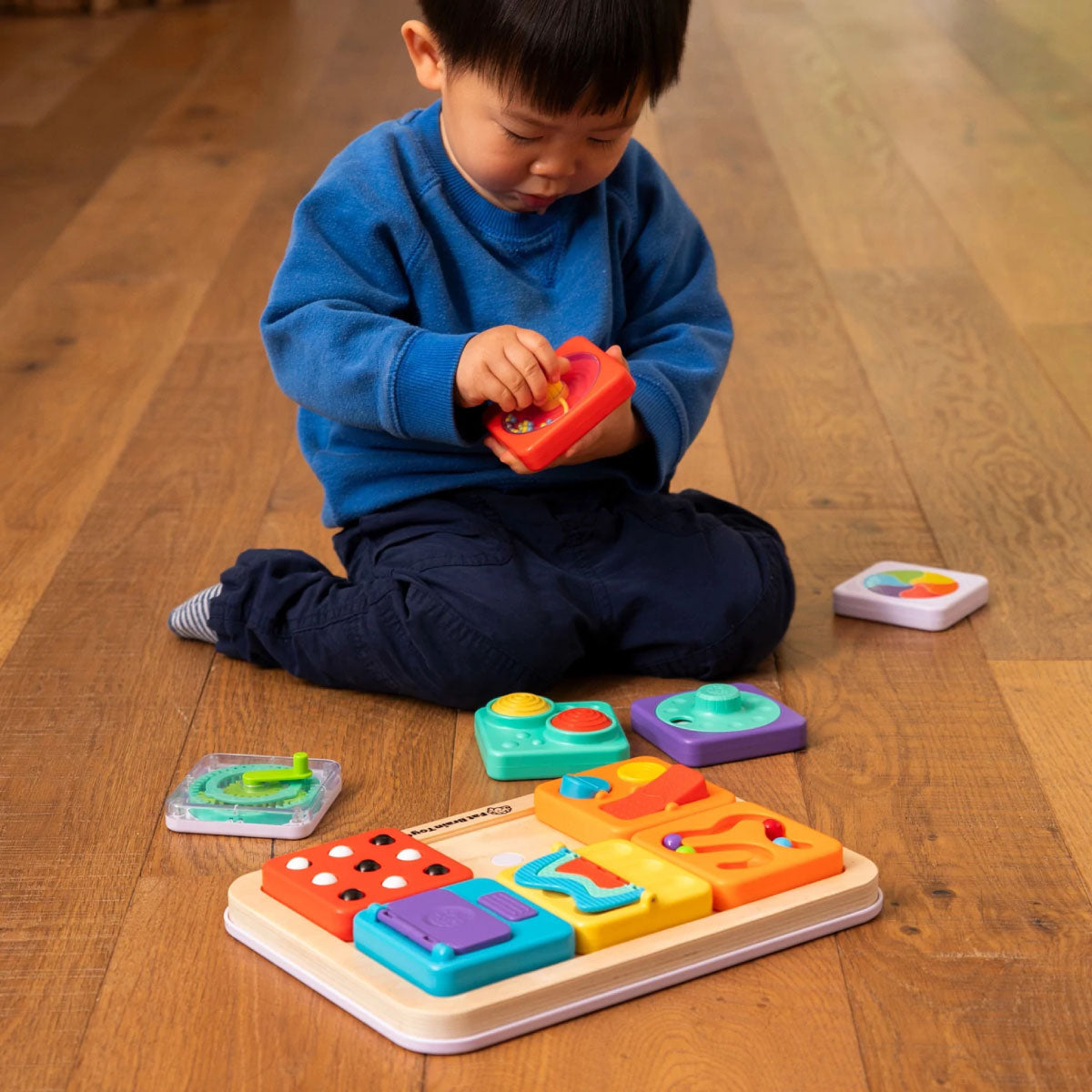 Toddler playing with the PlayTab Modular Sensory Board from Fat Brain Toy Co