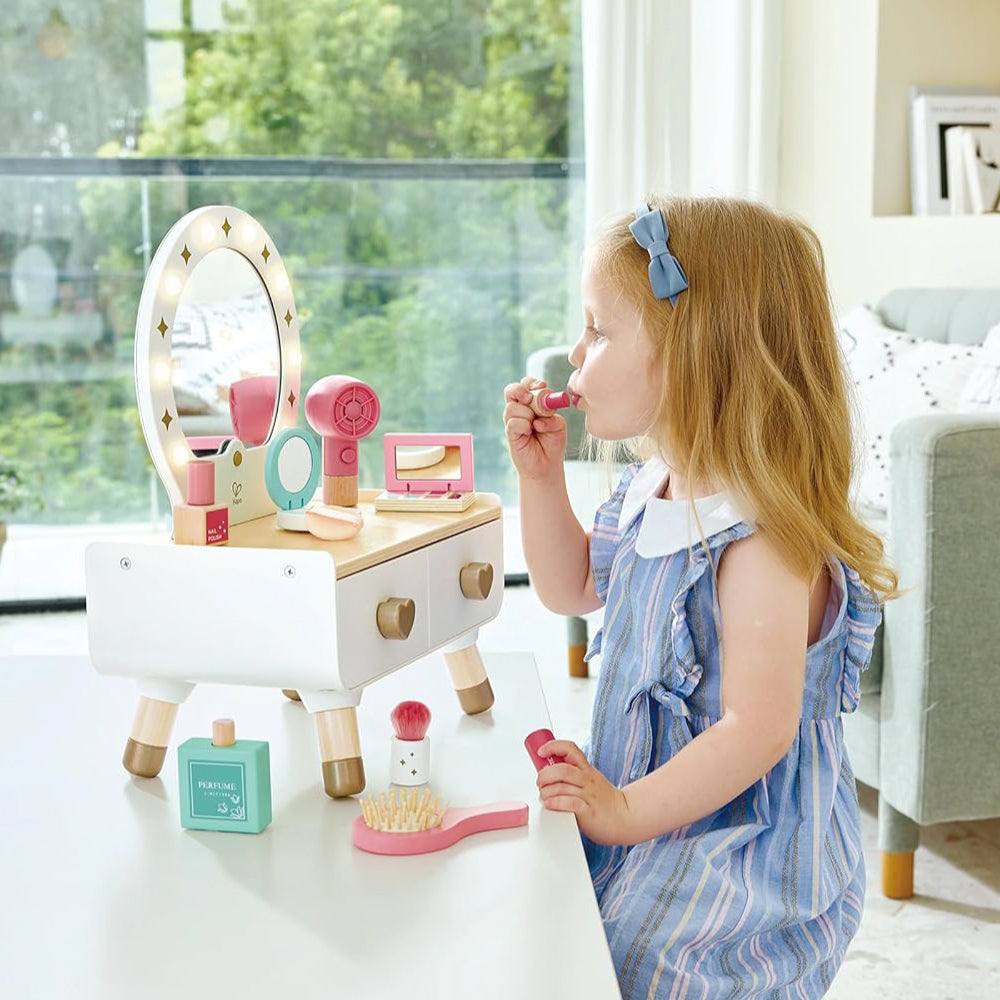 Child playing with the Hape My Stylish Dressing Table and pretend makup set.
