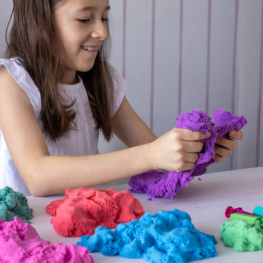Child playing with many colors of Mad Mattr sensory dough.