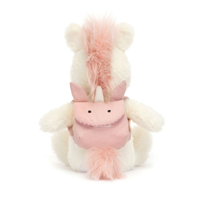 A plush unicorn wearing a pink unicorn backback, by Jellycat.