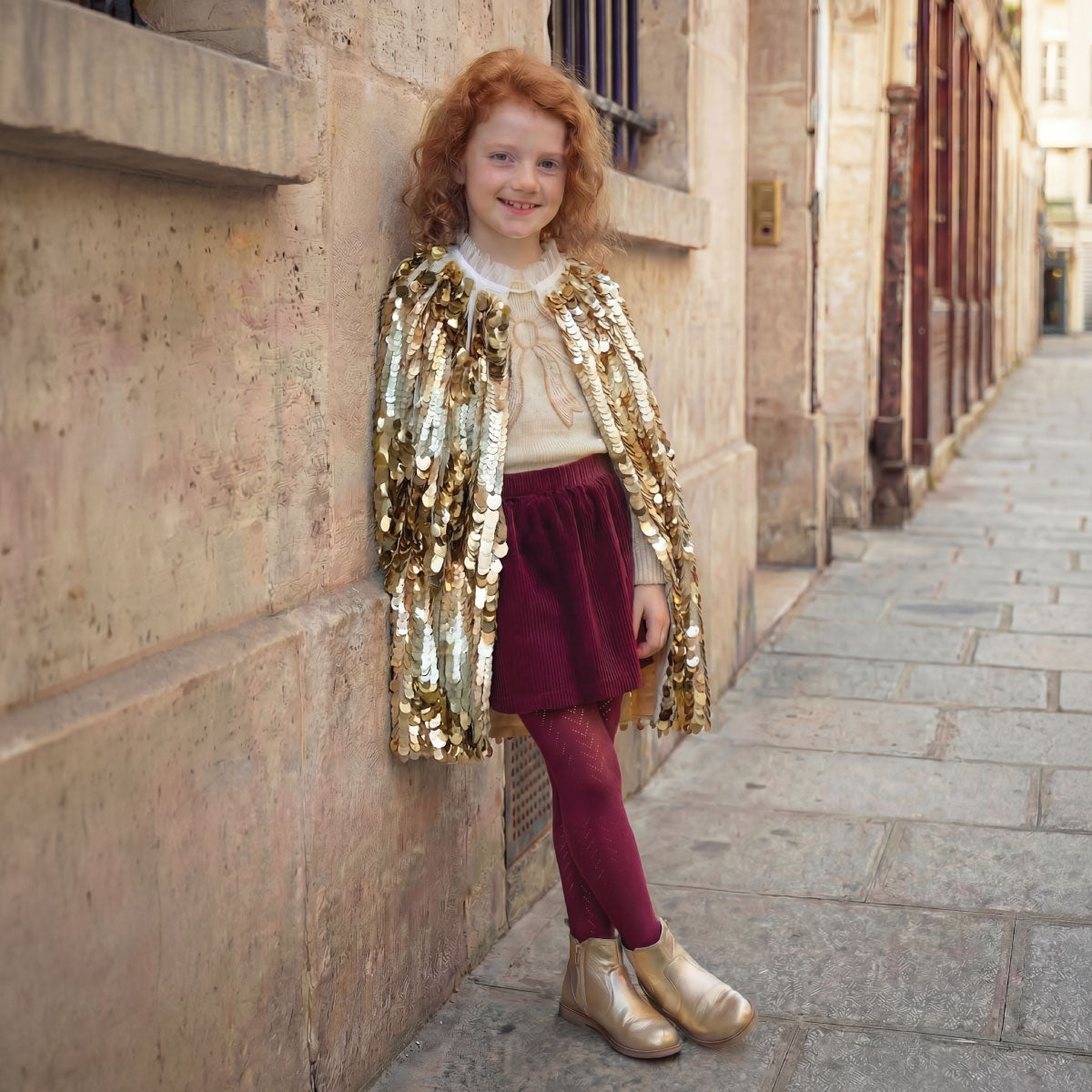 Child wearing the Great Pretenders 5th Avenue Paillette Cape in Gold
