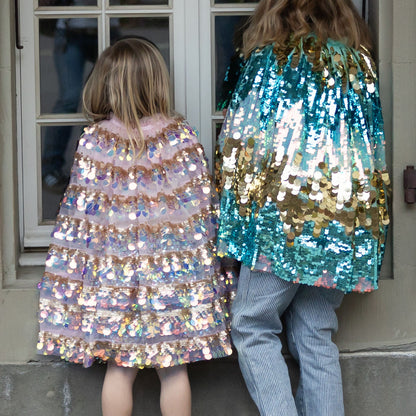 Children wearing the Great Pretenders 5th Avenue Paillette Capes in Pink and Mermalicious (Aqua-blue and Gold)