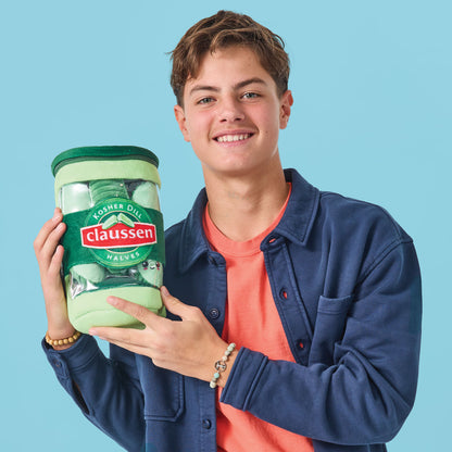 iScream's Claussen Pickles Packaging Plush being held by a young man.