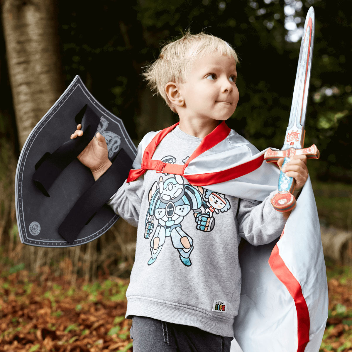 Child dressed up and playing with Liontouch Amber Dragon Knight Sword, Shield, and Cape