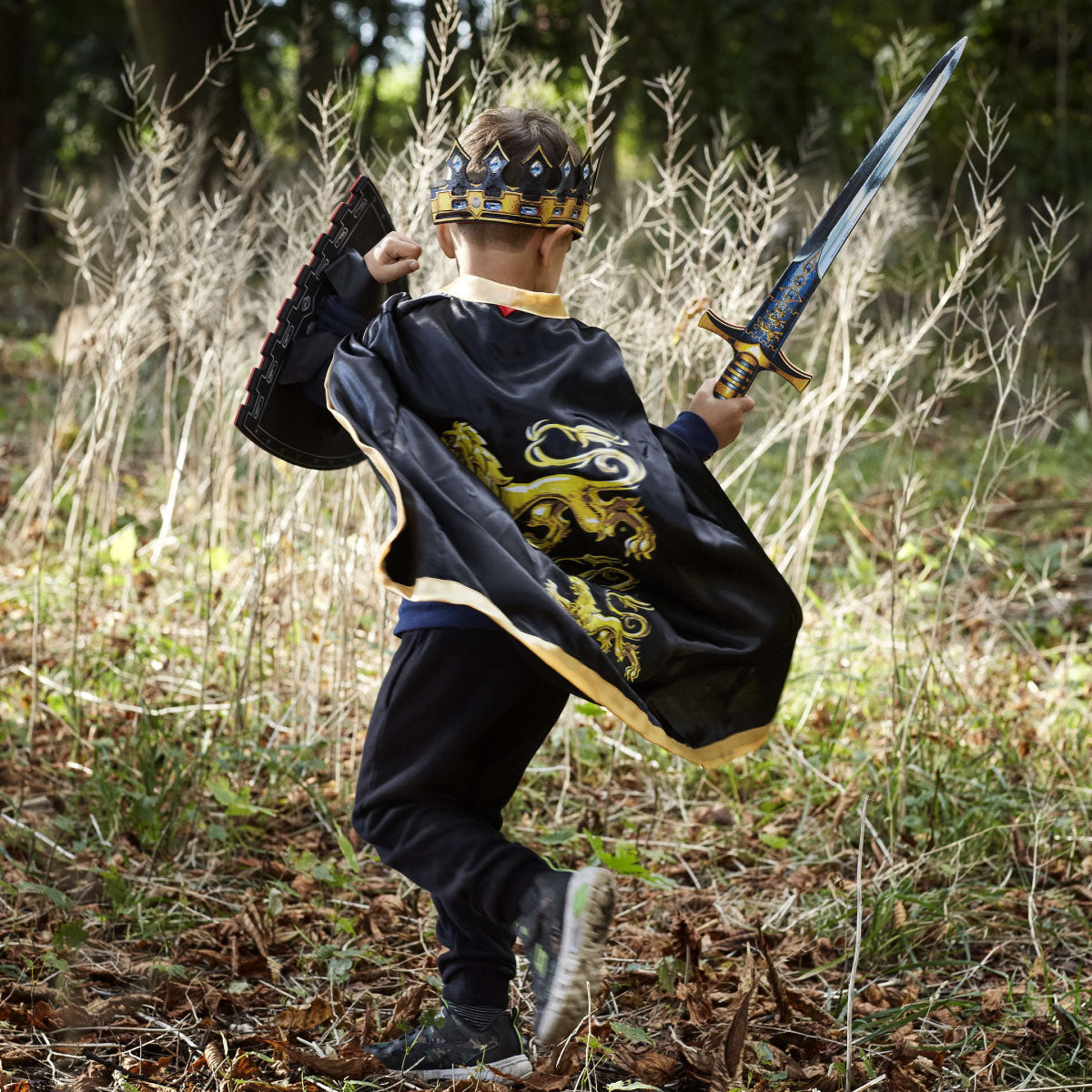 Child playing with Liontouch Triple Lion King sword, shield, cape, and crown