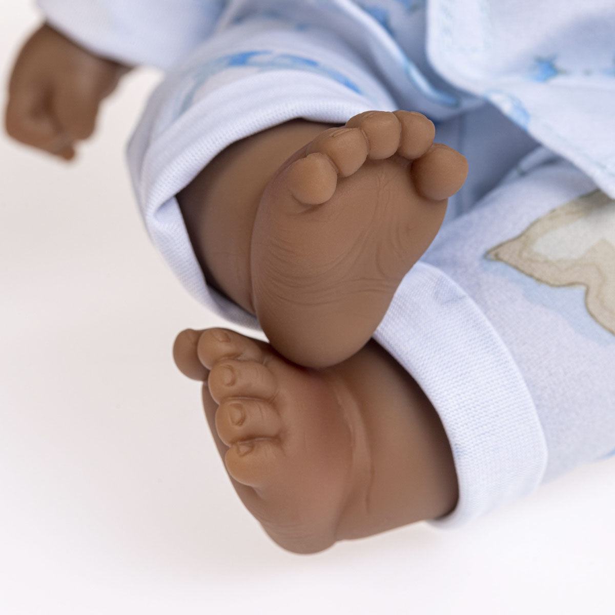 Close up photo showing detail of feet. Lots to Cuddle Babies 13" twins soft body baby dolls with brown-black skin. One wearing pink pajamas, the other in blue.