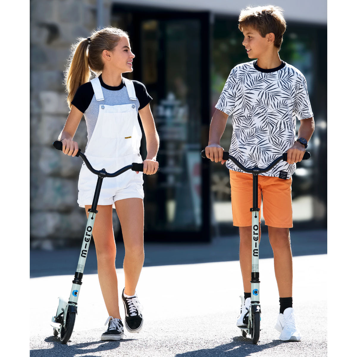 Micro Kickboard Speed Deluxe Scooters with teens riding