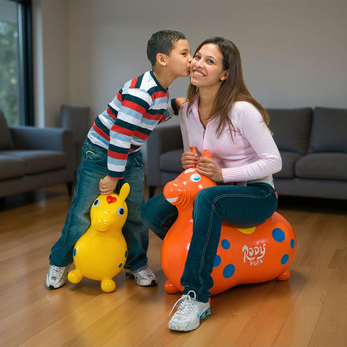 A child riding the original Rody horse with an adult riding Rody Max