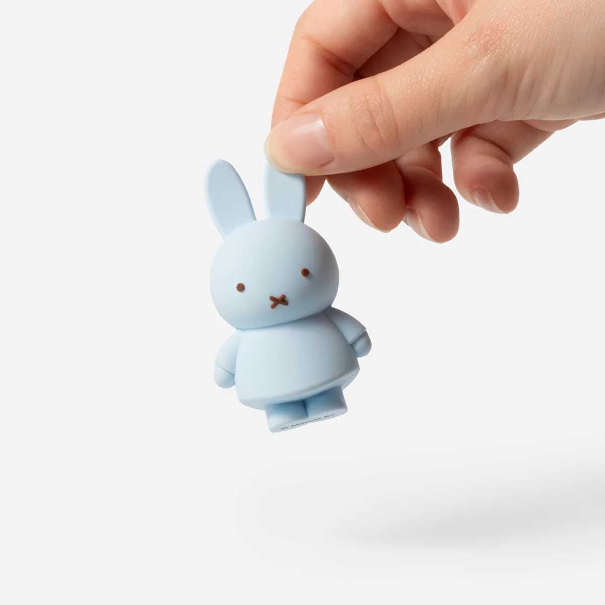 Hand holding blue Smoko Miffy Goes Pastel Blind Box Figure by the ear