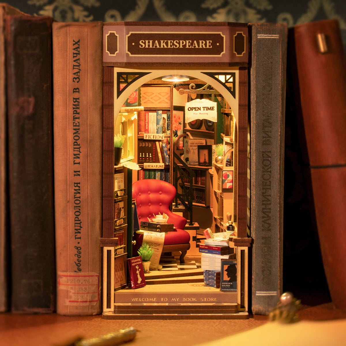 DIY Miniature Book Nook Kit, Shakespeare-inspired Bookstore, on bookshelf with warm lighting inside, from Hands Craft.