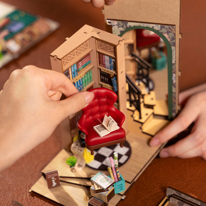 Hands assembling the DIY Miniature Book Nook Kit, Shakespeare-inspired Bookstore, from Hands Craft.