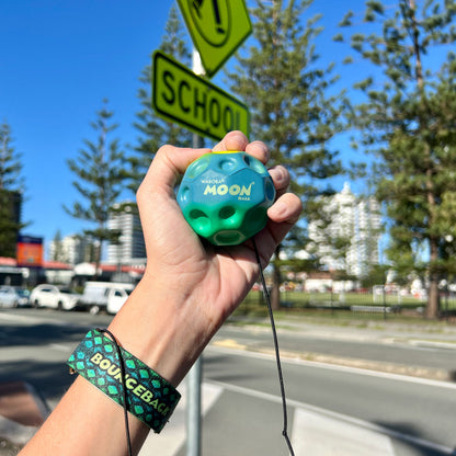 Waboba Gradients BounceBack Moon Ball 2.5” - Green/blue/yellow in hand