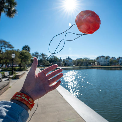 Waboba Gradients BounceBack Moon Ball 2.5” - Yellow/orange/red in hand